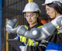 A team of female engineers meeting to inspect computer-controlled steel welding robots. Plan for rehearsals and installation for use.