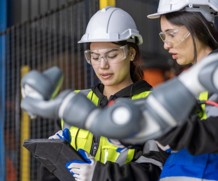 A team of female engineers meeting to inspect computer-controlled steel welding robots. Plan for rehearsals and installation for use.